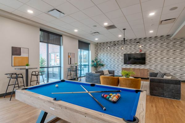 Club room at Chronicle on 8th with a pool table, TV lounge seating, and space to hang out.
